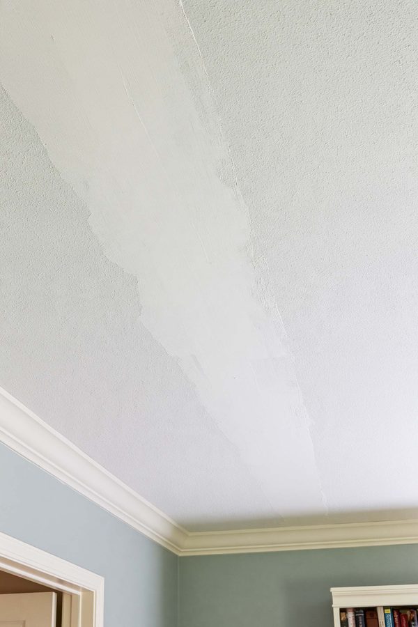 Unpainted ceiling seam repair with joint compound beside the existing textured surface.