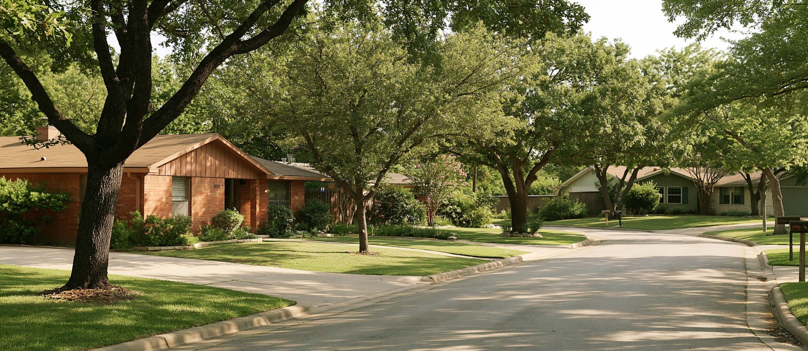 Illustrative residential street with single-story brick homes and mature shade trees.